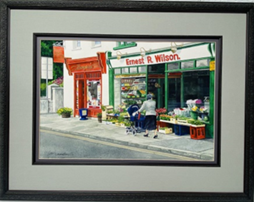 Window Shopping: Hillsborough, N. Ireland- Original Watercolor Painting by Lotus MacDowell, ARtworks, WV.  There's something magical about small villages, especially throughout Europe. Lotus MacDowell has captured a moment in time with a scene from a small village in Northern Ireland. The atmosphere is typical Ireland- a clear gray day as a woman walks through the town, pushing a baby carriage and sizing up the flowers in front of the grocery store.